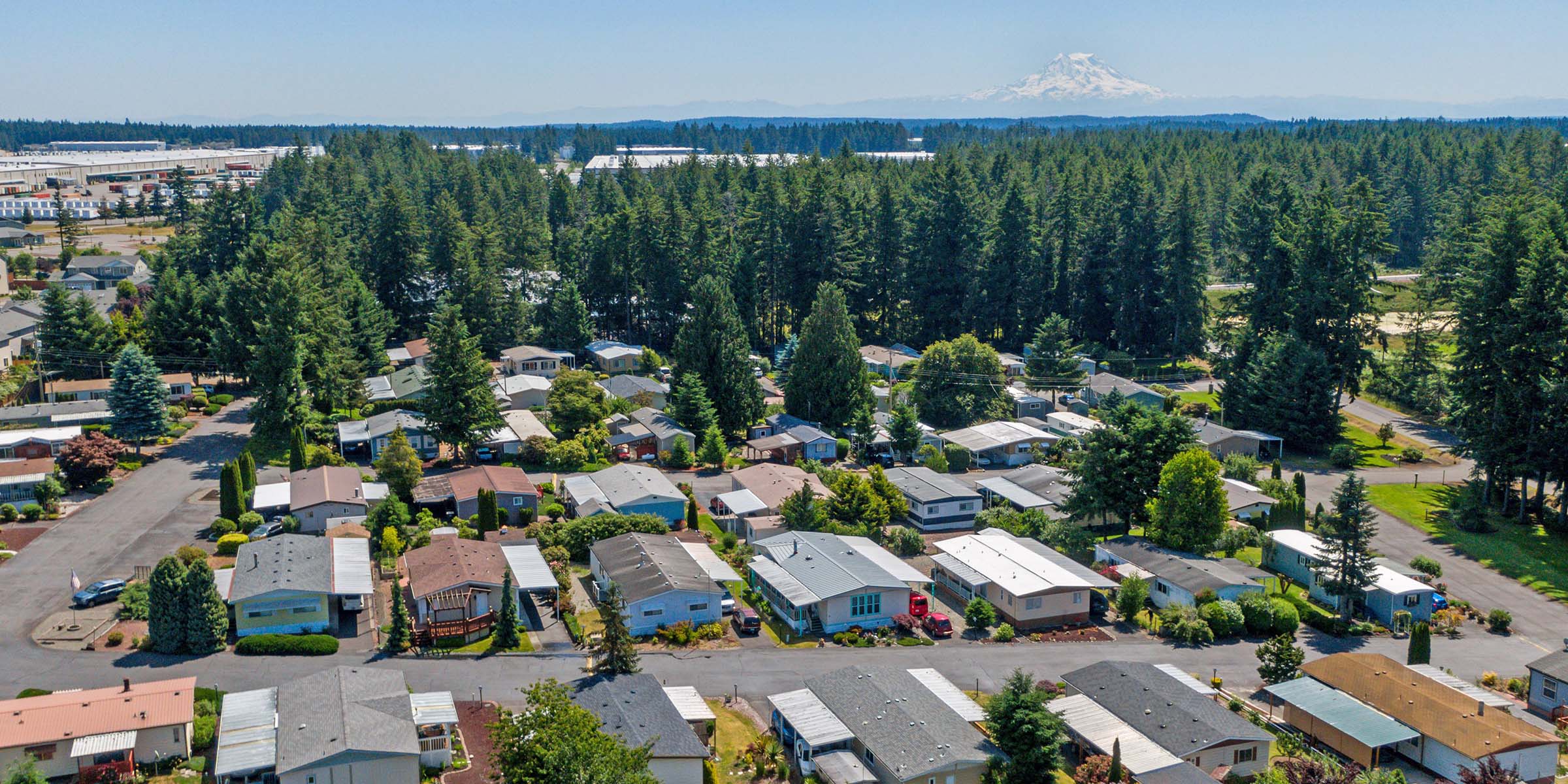 An aerial view of a mobile home park with mountains in the background.