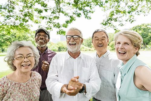 Smiling group of older friends standing outdoors